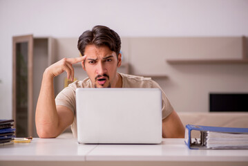 Young male employee working from house