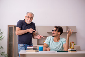 Young male student and his grandfather at home