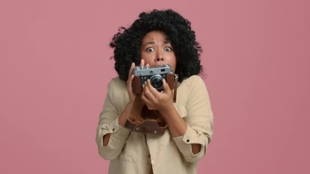 Slow Motion young African American photographer woman of color taking picture of unexpected, unbelievable surprising WOW, no way moment or event with vintage film camera, shot on retro photo camera 4K