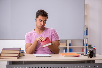 Young male student preparing for exams in the classroom