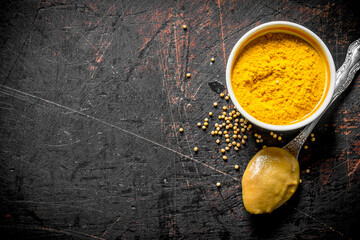 Mustard in a bowl and spoon.