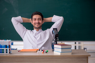 Young male chemist sitting in the classroom