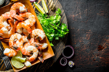 Shrimps on tray with parsley, lime slices and onion rings.
