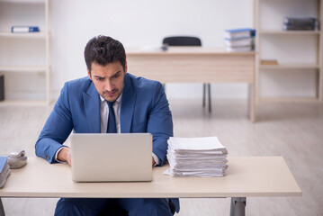 Young male employee and too much work in the office