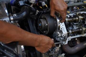 Fototapeta na wymiar Hands working on car's engine in a garage