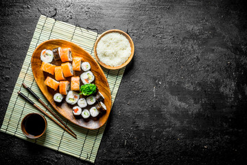 Japanese rolls on a plate with rice and soy sauce.