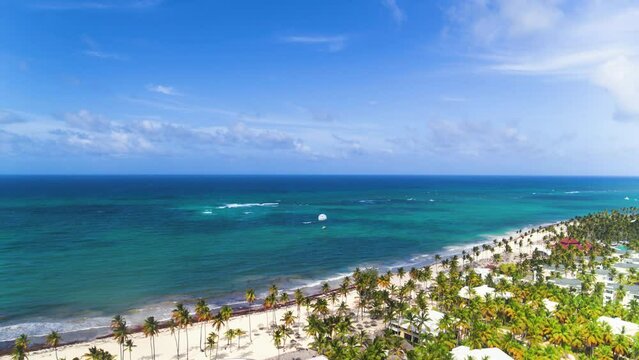 Aerial view of the tropical resort of Punta Cana on Bavaro Beach in the Dominican Republic. Ocean top view. Beautiful Atlantic tropical beach with palm trees, umbrellas and parasailing balloons.