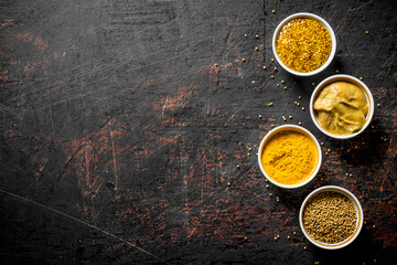 Different kinds of mustard in the bowls.