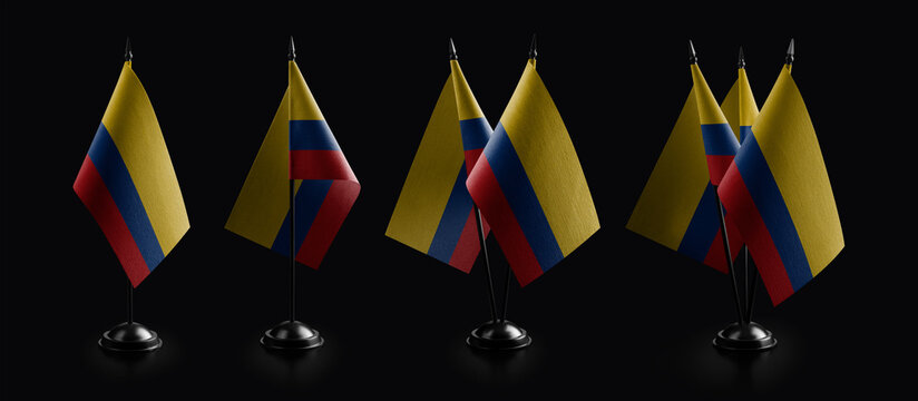 Small national flags of the Colombia on a black background