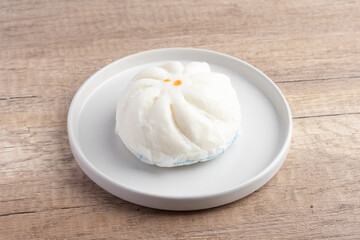 Steamed pork buns in a plate on a white background