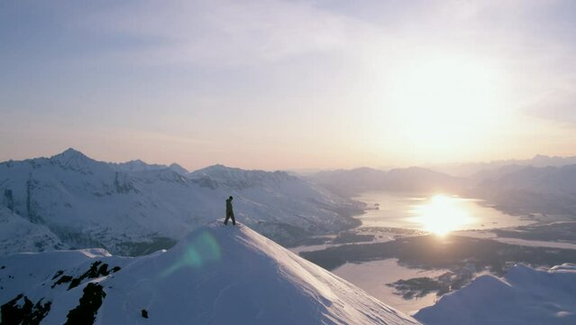 A man snowboarding down a remote mountain in coastal Alaska