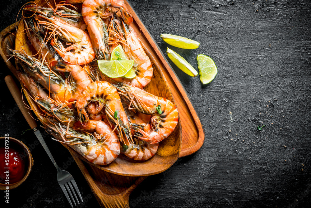 Wall mural cooked shrimps in a plate on a cutting board.