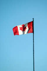 Canadian flag high in the sky outdoors.