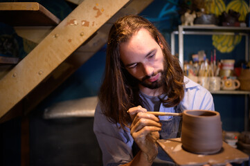 Pottery artist, Young making a piece of clay molding calmly and meticulously In order to produce...