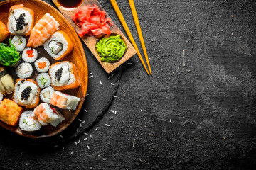 Traditional Japanese rolls and sushi in a plate on a stone Board.
