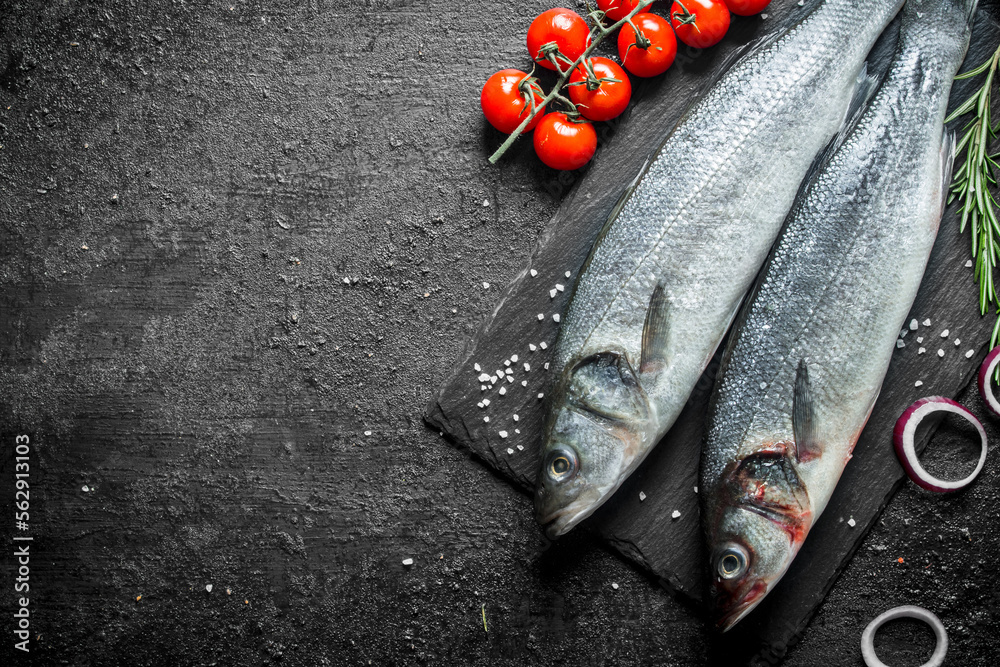 Sticker fresh fish raw seabass with tomatoes, onion rings and rosemary.