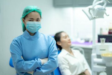 Asian woman dentist doctor and female patient in chair smiling at camera, Visiting dentist.