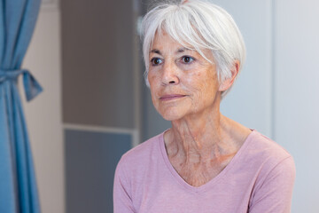 Smiling caucasian senior female patient in hospital room, with copy space