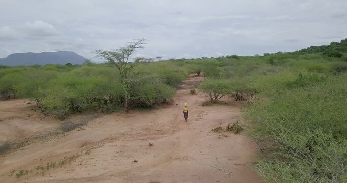 African Woman Walking with a bucket of Water