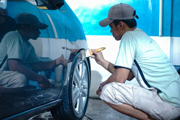 worker cleaning car rim