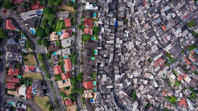 Two Contrasting Residential Neighborhoods in Sao Paolo, Brazil. Wealthy Gated Neighborhood next to impoverished Favelas. separated by a Wall.  Gimbal overhead bird's eye, tracking forward.