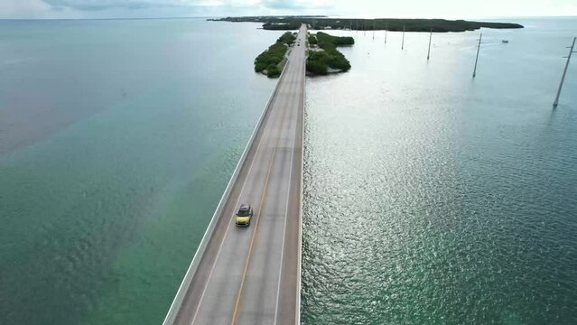Yellow car driving across bridge on Florida keys overseas highway