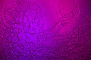 Top view movement of bubbles in the liquid. Oil surface multicolored background. Fantastic structure of colorful bubbles. Colorful artistic image of oil drop floating on the water.