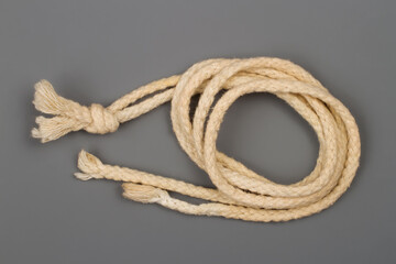 A coil of rope on a gray background.