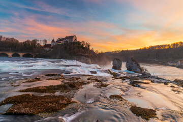 Rhine Falls or Rheinfall, Switzerland panoramic view. Tourist boat in waterfall. Bridge and border...