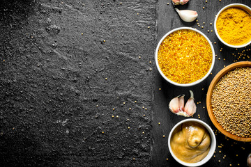 Different types of mustard with garlic cloves.