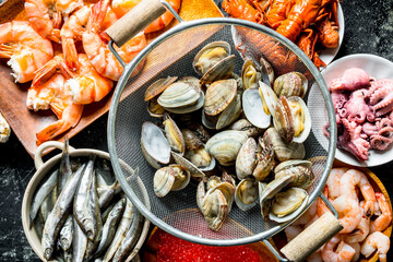 Oysters in a colander with shrimp, baby octopus and crayfish.