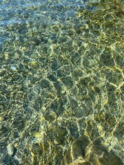 Clear sea water with pebbles and stones at the bottom.