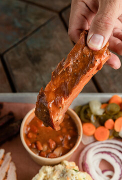 Holding a Barbecue Rib Above a Tray