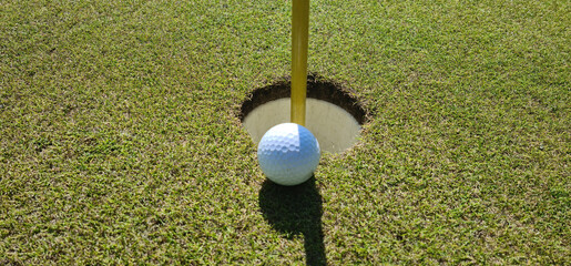 Golf ball in the hole closeup. Golfing