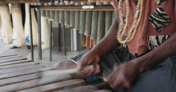 traditional african marimba player in traditional costume playing outdoors