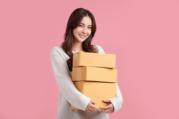 Beautiful Young Asian woman holding parcel box isolated on pink background, Delivery courier and...