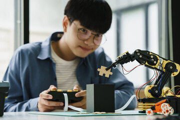 Asian teenager students doing or playing robot arm and robotic cars homework project in house...