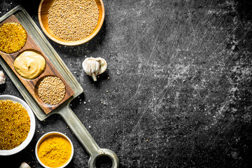 Fototapeta na wymiar Different types of mustard on a cutting Board with garlic.