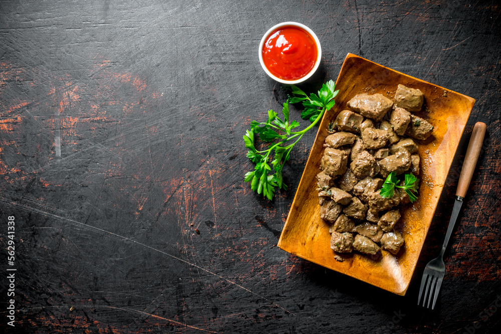 Sticker pieces of fried liver with parsley and sauce.