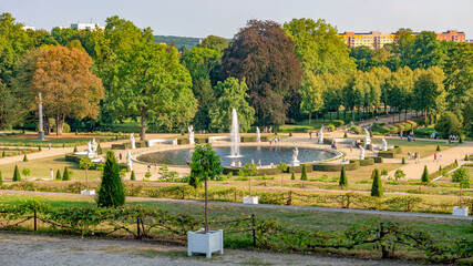 Panoramic view over garden, pools, flowers, old statues, fountains and many tourists in the city...