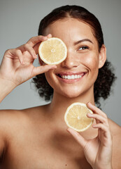 Face, skincare and woman with lemon in studio isolated on a gray background. Fruit, organic...