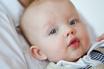 Closeup indoor portrait of a cute happy toddler boy with blue eyes	