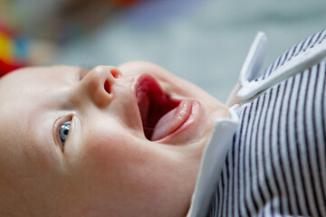 Closeup indoor portrait of a cute happy toddler boy with blue eyes