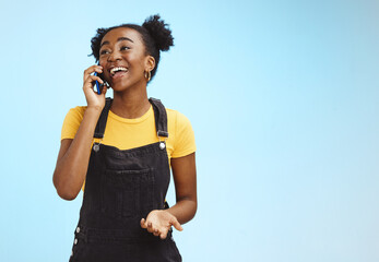 Communication, happy and talking black woman on a phone call isolated on a blue background....