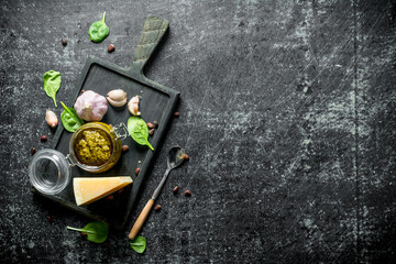 Obraz na płótnie Canvas Pesto sauce on a cutting Board with Parmesan, Basil and garlic.