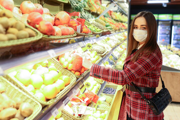 A young woman in the vegetable department of a supermarket. Selection of products in the store