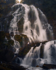 Fototapeta na wymiar a man standing alone in the giant waterfall