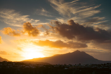Houses of Procida in magic sunset with the island of Ischia in the background.