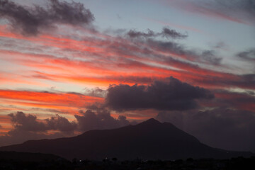 Houses of Procida in magic sunset with the island of Ischia in the background.