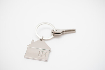 Metal key chain in the shape of a house with a metal key